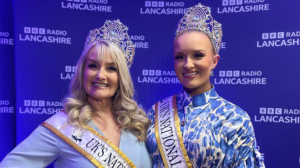 Dawn, with long blonde curly hair and Eden Ronson with her hair swept back, both wear their crowns and sashes.