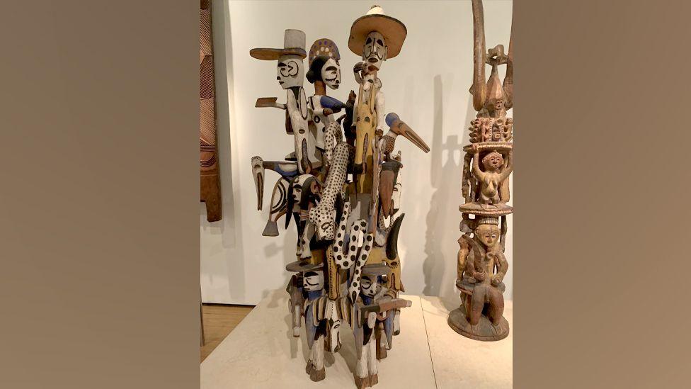 Wooden stature featuring several figures on display at museum