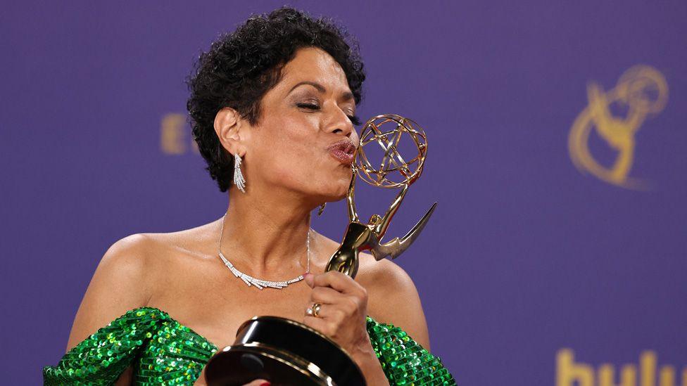 Liza Colon-Zayas kissing her Emmy Award