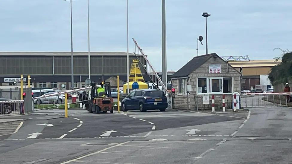 A taxi arriving at the port where the Bibby Stockholm barge is located