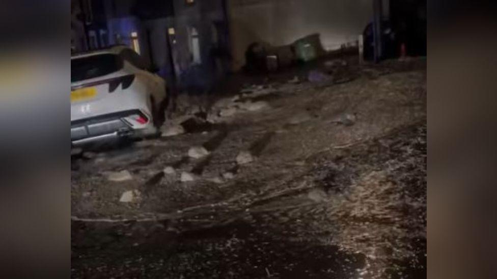 Videos on social media shows a street swamped in mud