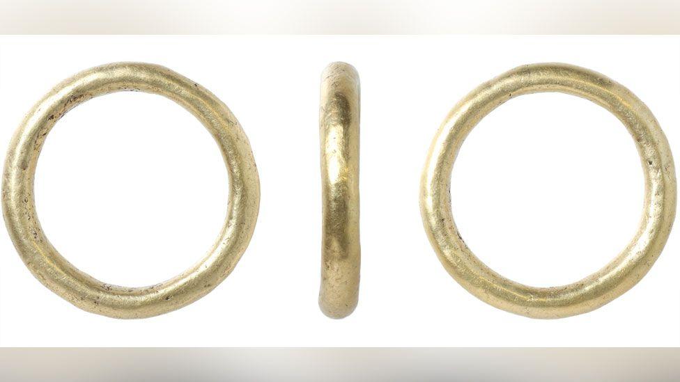 Three views of a heavy round gold Roman ring, front back and side. It is in incredibly good condition and appears undamaged by centuries in the ground. It is completely plain and its band is rounded 