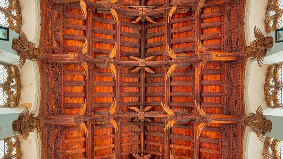 Looking up at St Wendreda's angel roof. At least 22 angels can be seen, either whole or in part. Some are attached to the ceiling beams and others are attached to the wall below the roof and beside the windows