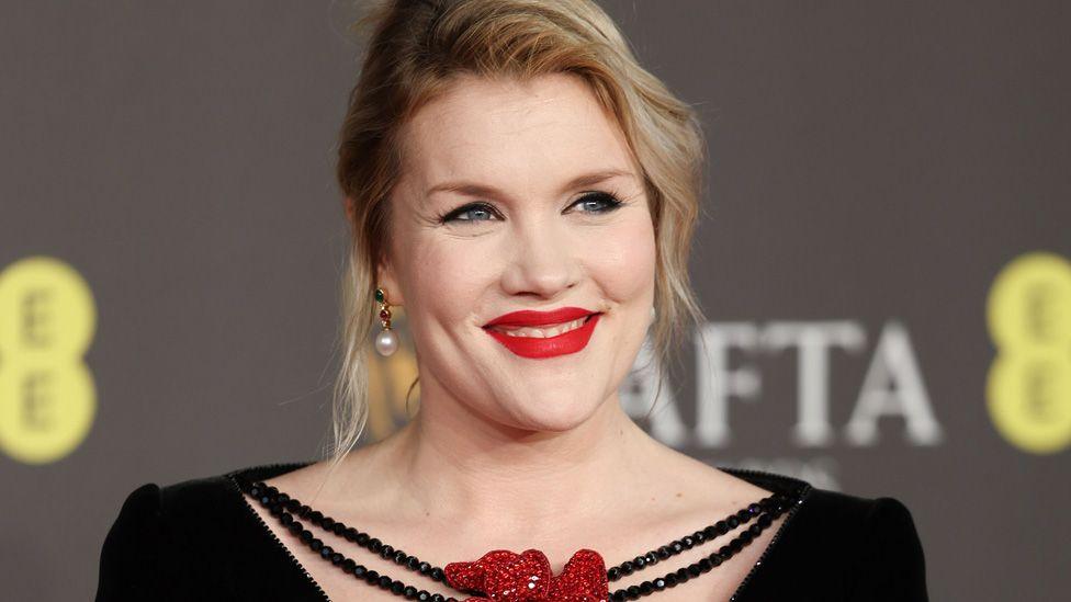 Emerald Fennell smiling on a Bafta red carpet