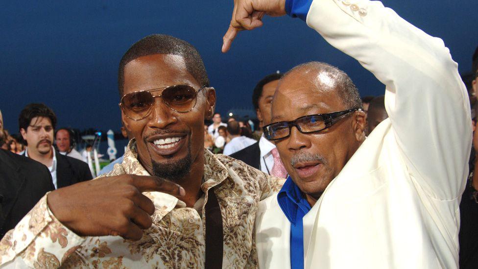 Jamie Foxx and Quincy Jones playfully pointing each other with their arms around each other on the 2005 MTV Video Music Awards red carpet