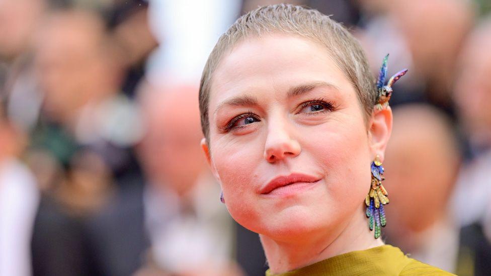 Émilie Dequenne with short hair and colourful earrings on the red carpet at the 2024 Cannes Film Festival