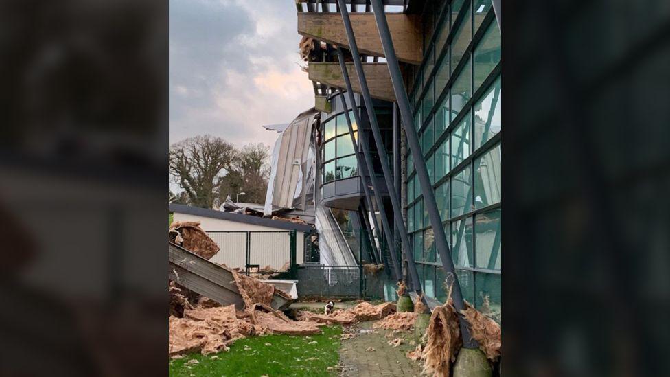 A lot of damage has been done to the roof, the insulation can be seen all over the grass outside of the centre.