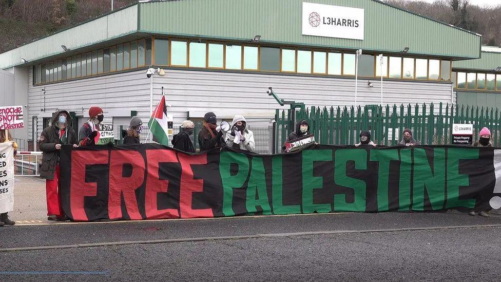 protesters holding a banner reading Free Palestine outside the L3 Harris factory in Brighton