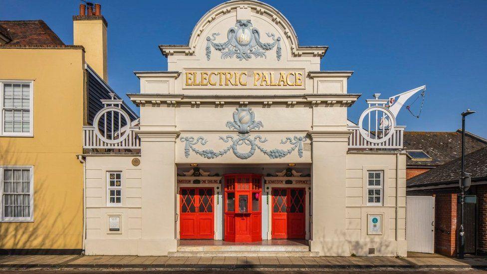 The Electric Palace seen from the outside. It has red doors and gold lettering on top that says Electric Palace.