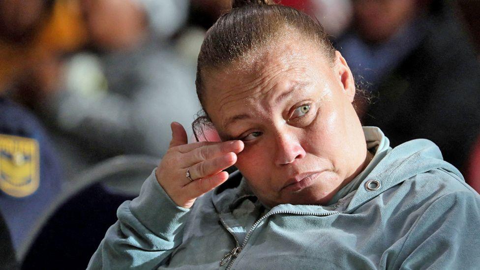 Racquel Smith, also known as Kelly Smith, wearing grey tracksuit wipes her eye during her sentencing at the Western Cape High Court in Saldanha Bay, South Africa - 29 May 2025.