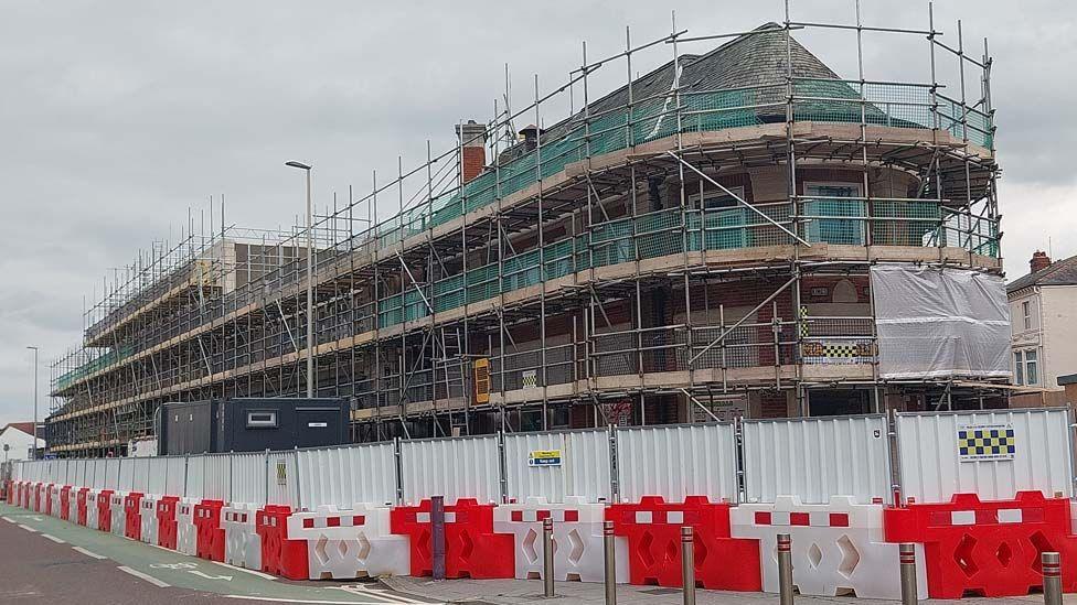 Street view of the art deco Stanley Buildings covered in scaffolding