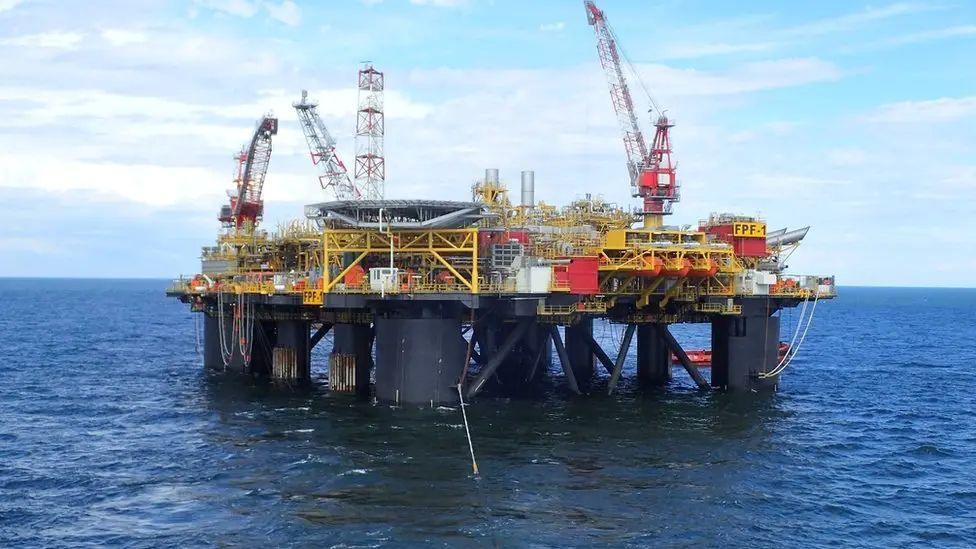 A floating production facility with large legs, in the sea.