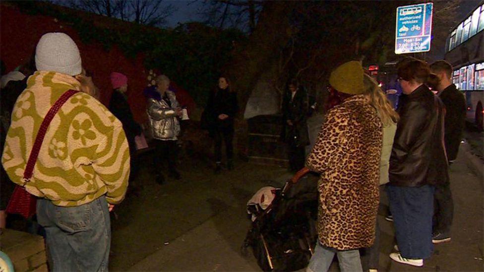 Marchers on a previous Say Her Name event stand on a winter's night a around a bench in Hull where murdered student Libby Squire was last seen alive