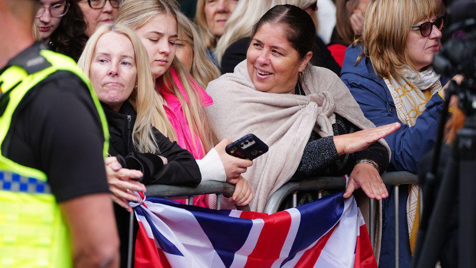 Members of the public with a Union Jack wait for guests to arrive for the wedding of Hugh Grosvenor, the Duke of Westminster, to Olivia Henson at Chester Cathedral