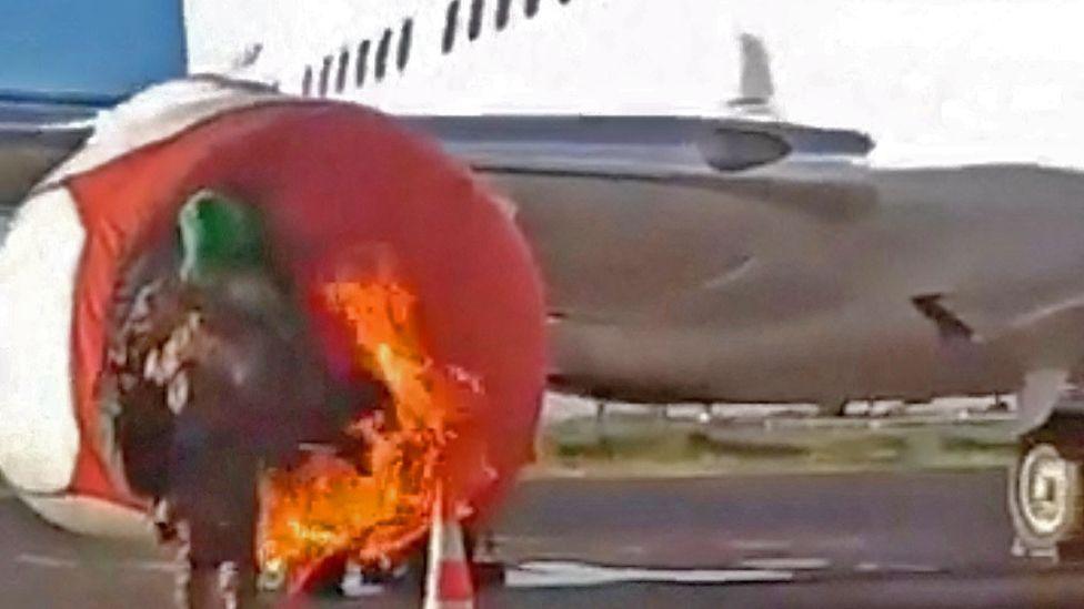 An armed individual sets fire to a plane at the international airport during an insurgent attack in Bamako, Mali, September 17, 2024, in this screengrab obtained from a social media video