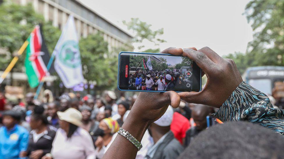 A protester uses a smartphone to film the protest in Nairobi, Kenya - 18 June 2024