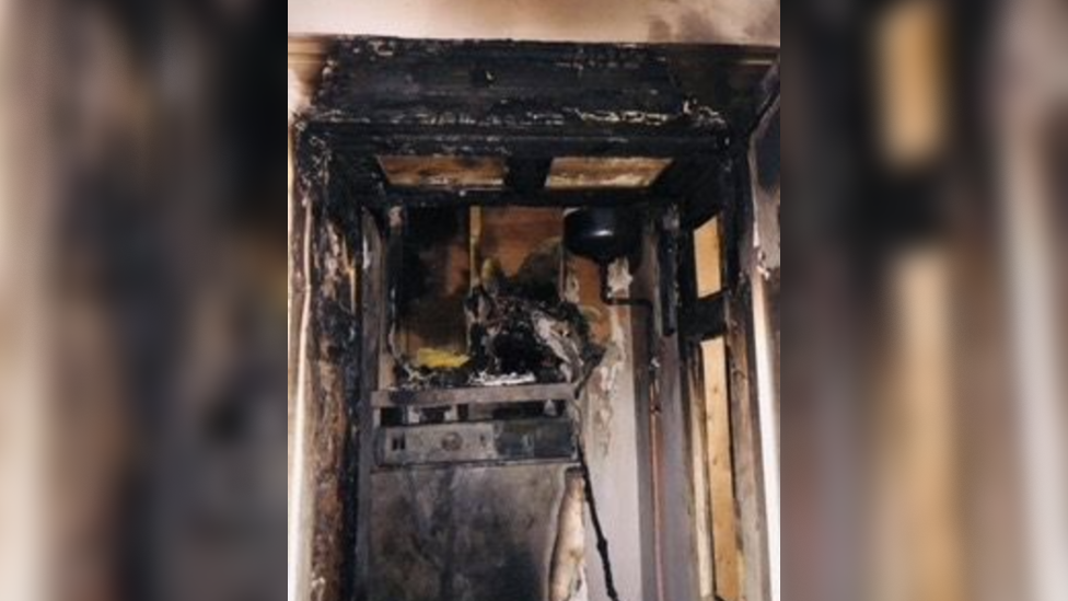 A burnt boiler cupboard which has been damaged by smoke and fire