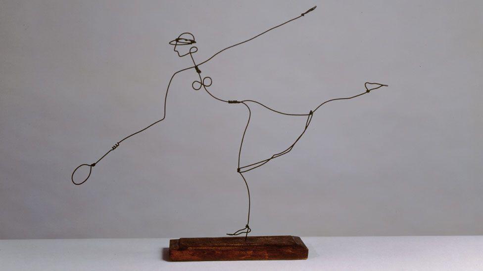 A wire sculpture attached to a wooden base showing the outline of a woman tennis player leaping to reach a ball, 1927 