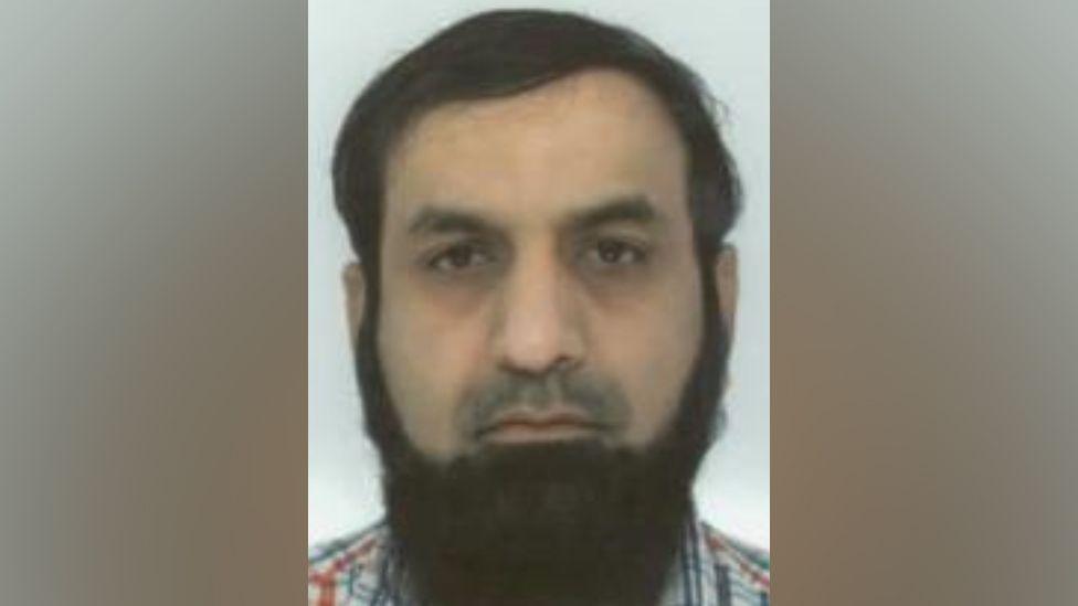 Mohammad Siddiqui mugshot - He has brown combed-over hair and a long brown beard.