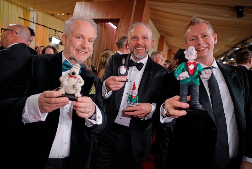 Nick Park, Richard Beek and Merlin Crossingham with figurines of Wallace and Gromit