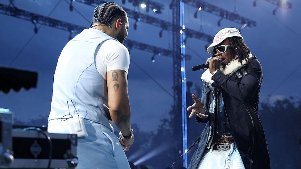 Drake appears in blue with Rema in a hat and fur rimmed jacket