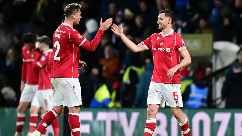 Wrexham's Dominic Hyam celebrates with team-mate Callum Doyle at the final whistle during the Emirates FA Cup Fourth Round match between Wrexham and Ipswich Town