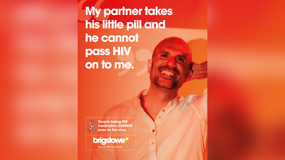 A HIV poster. A man is pictured with one hand on his head, looking at the camera and smiling. The poster is orange and red, with white text reading: "My partner takes his little pill and he cannot pass HIV on to me." There is also a Brigstowe charity logo and a message to say "People taking HIV medication CANNOT pass on the virus" 