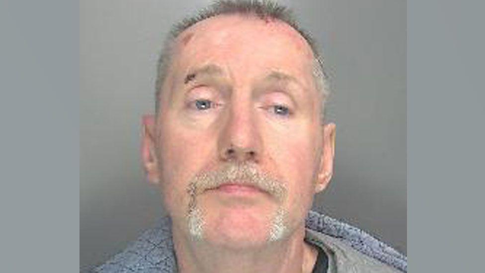 Jason O'Dell is looking at the camera in a police custody shot. He has short, greying hair and a moustache and partial beard.