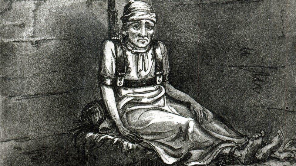 Vintage illustration showing a man bound and chained to a pipe, sitting on a straw mattress in a cell