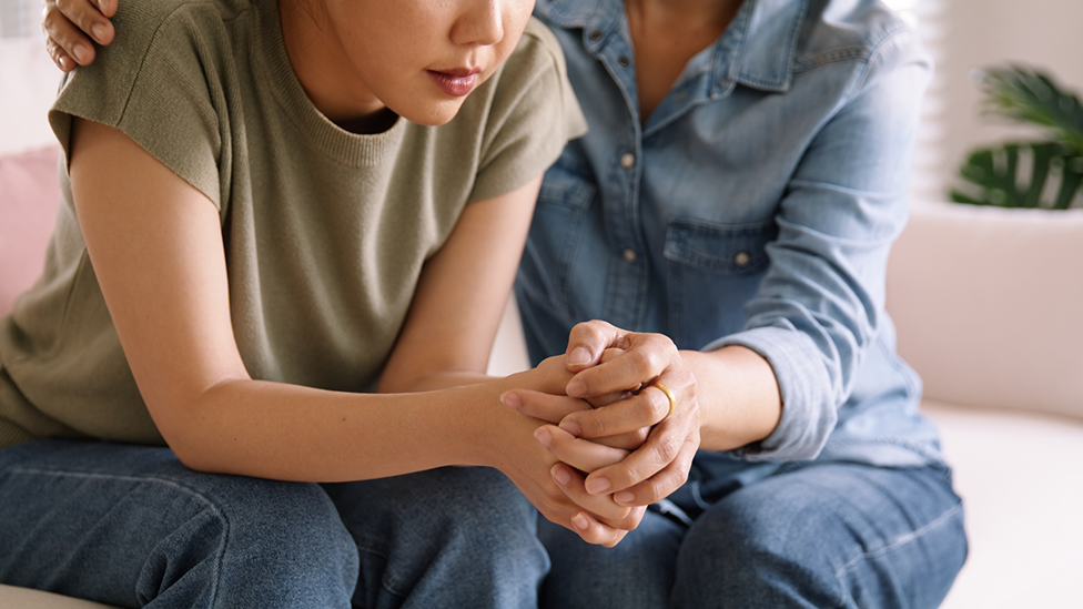 Person holding a child's hand