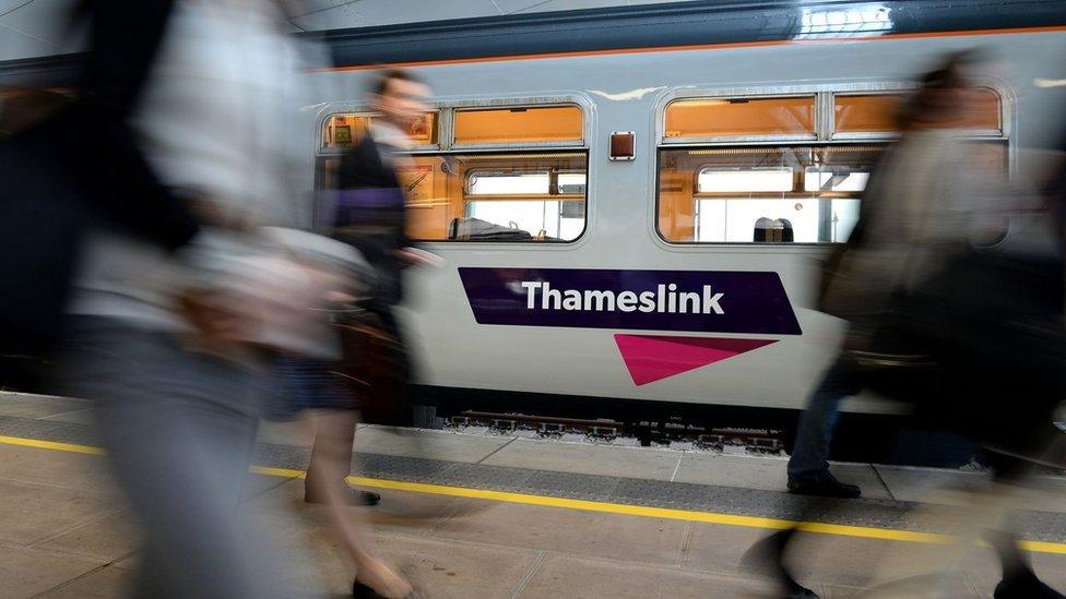 Passengers walking past a Thameslink train