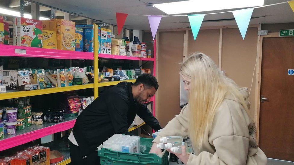 Two people at the Himmah charity help to organise donated food ahead of it being distributed to people in the city.