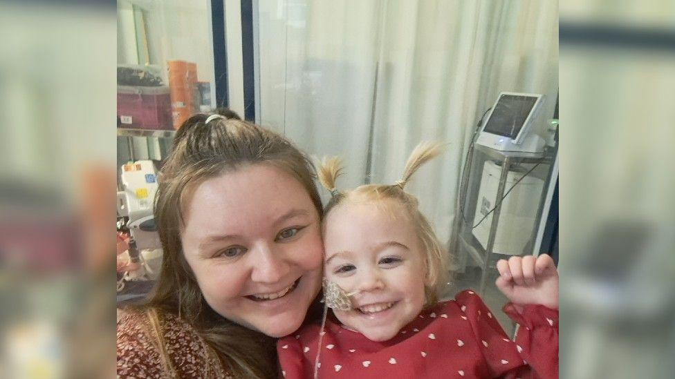 Selfie of mum Jodie and Amelia in a hospital room. Both have big smiles on their faces.