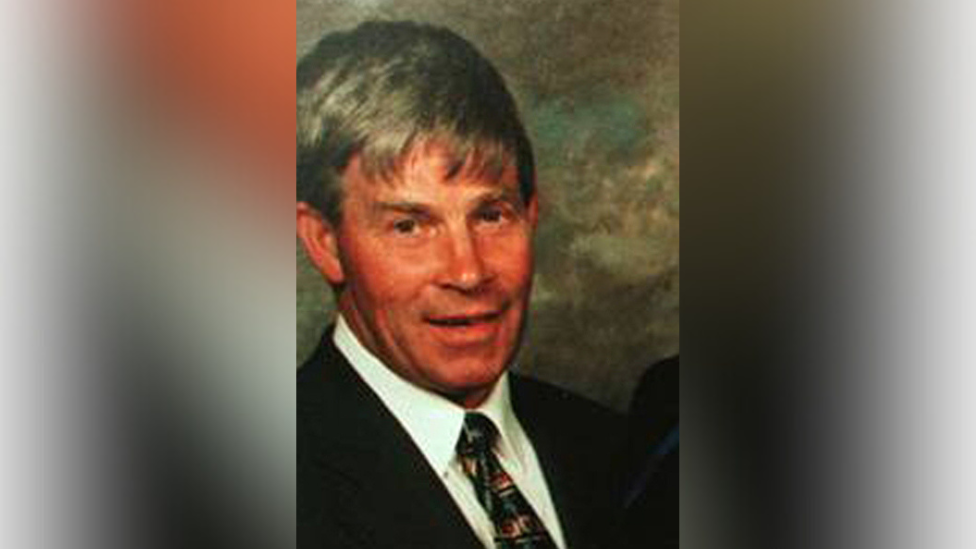 Man wearing a suit and tie smiling at the camera