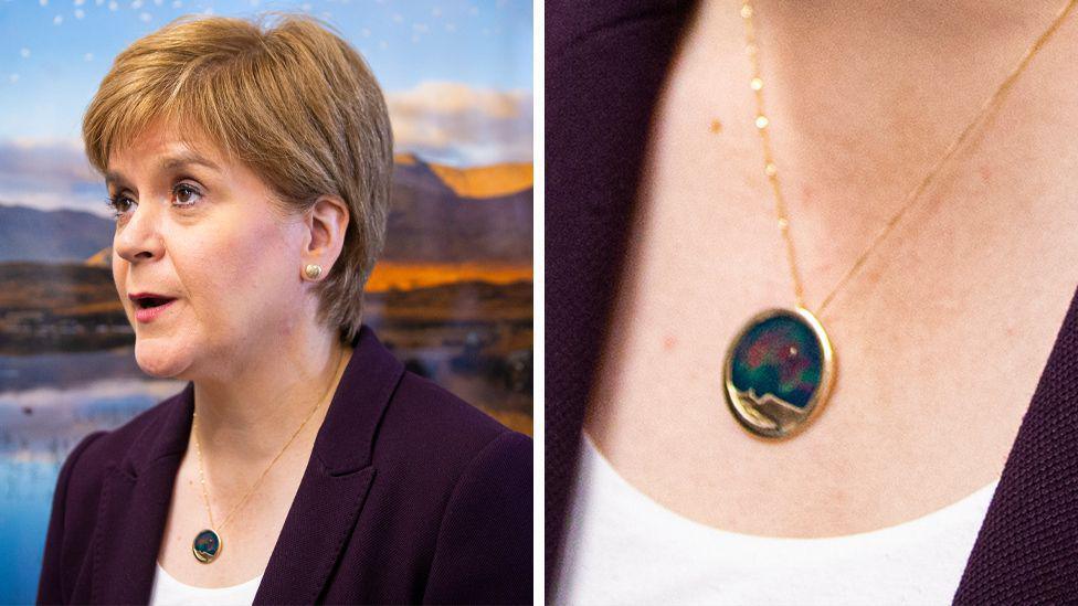 A composite image of Nicola Sturgeon wearing a necklace with a large gold pendant, inlaid with blues, reds and greens. There is a close up of the necklace on the right hand side.