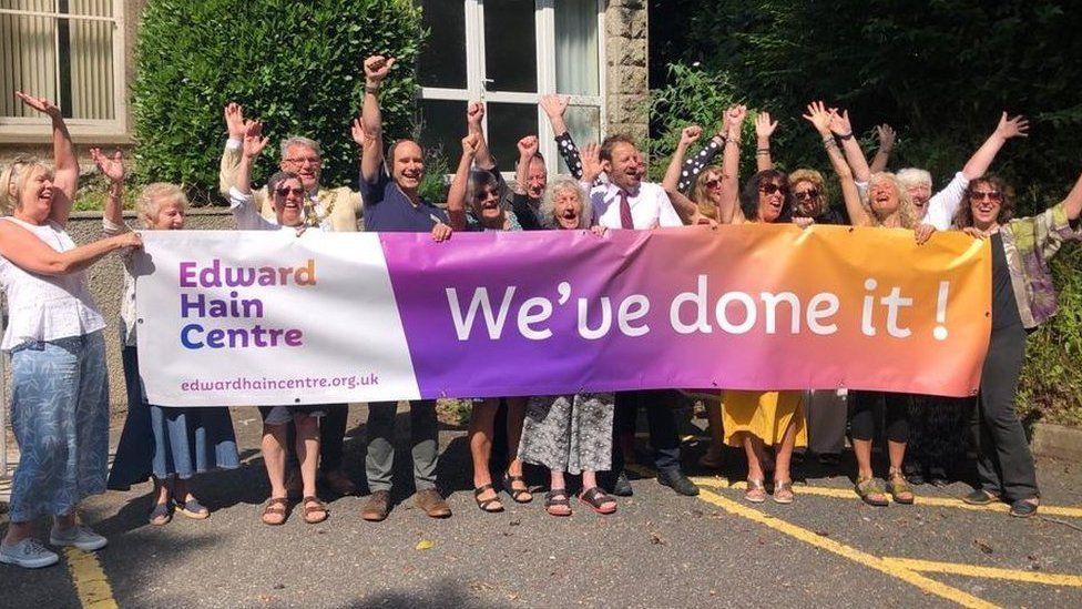 Residents with "We've done it !" banner