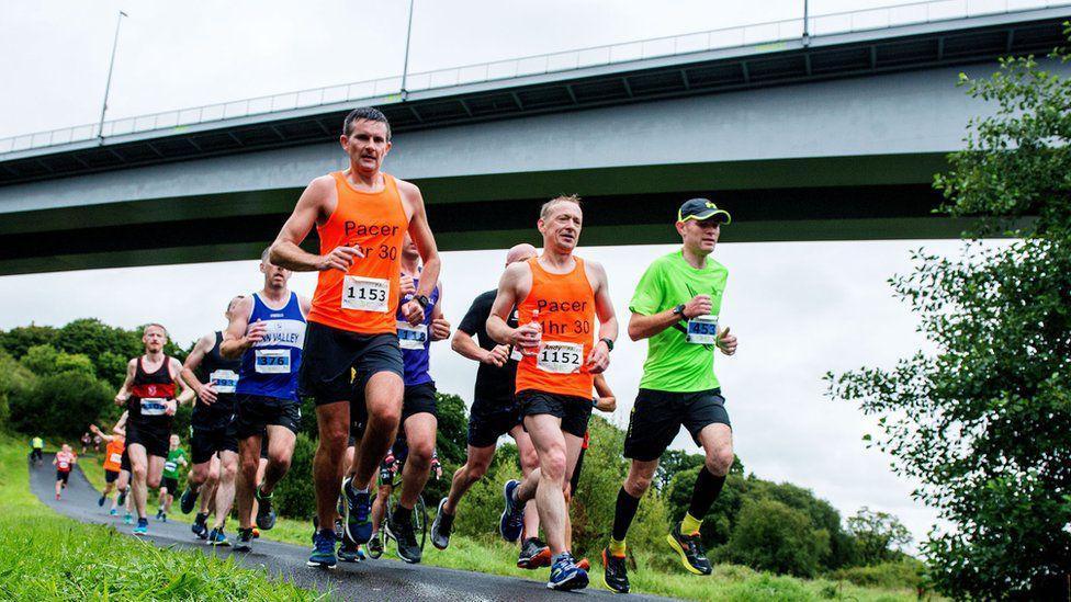 half marathon pace runners in derry with the foyle bridge in the background