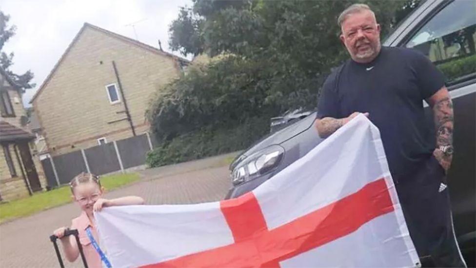 Willow with her grandfather holding England flag