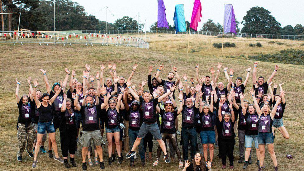 A group of festival volunteers and organisers jumping in the air