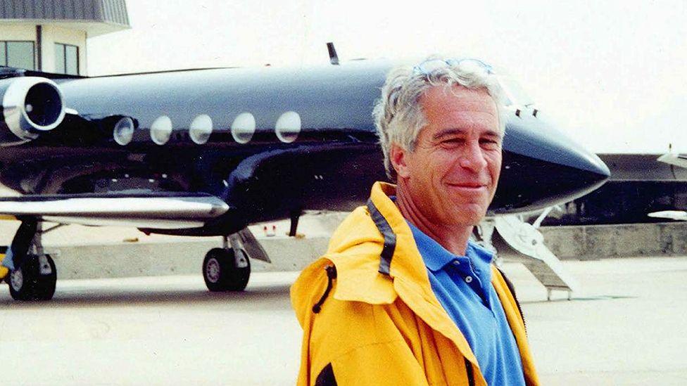 Jeffrey Epstein standing in front of his private plane