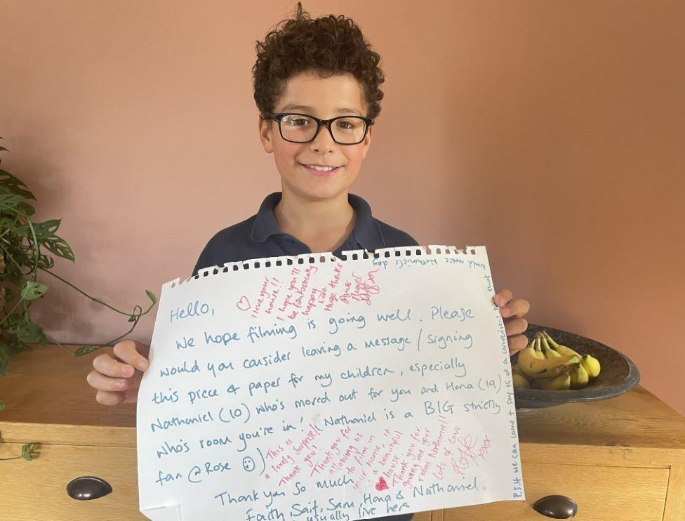 Nathaniel holding up a thank you letter from Rose Ayling Ellis