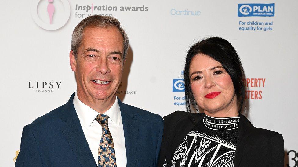 Nigel Farage, in a suit and tie, poses for the cameras with Laure Ferrari, at the 2024 Inspiration for Women awards