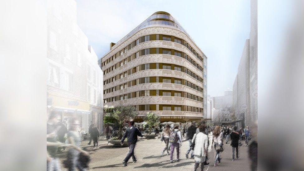 A computer-generated image of what the building might look like. It's a building of at least nine storeys with a modern-looking pale brick facade and rows of large windows and balconies on each floor. It's set on the corner of a busy pedestrianised street