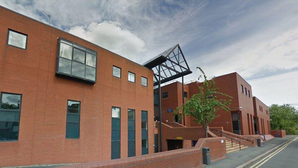 The outside of Leicester Crown Court - it's a long brick building with small windows at the top and long ones at the bottom