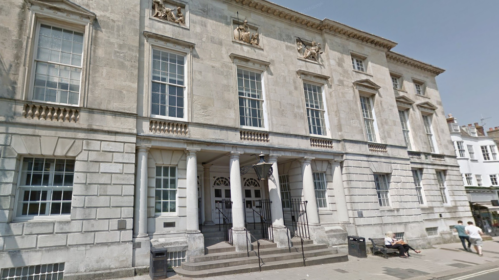 Outside Lewes Crown Court, a large, grey stone building with four large pillars and stone steps at the entrance