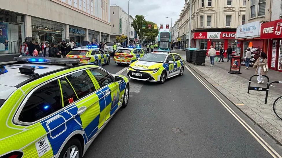 Four police cars and a taped off road at Western Road in Brighton