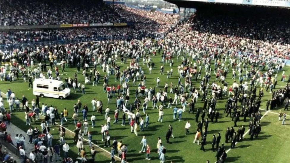 Ambulance and people on the pitch during the Hillsborough stadium disaster.