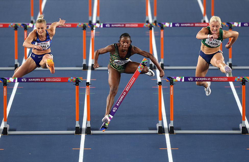 Ackera Nugent of Jamaica knocks off a hurdle as she competes against Finland's Lotta Harala and Republic of Ireland's Sarah Lavin in the Women's 60 metres hurdles on day three of the World Athletics Indoor Championships in Nanjing, China on 23 March.