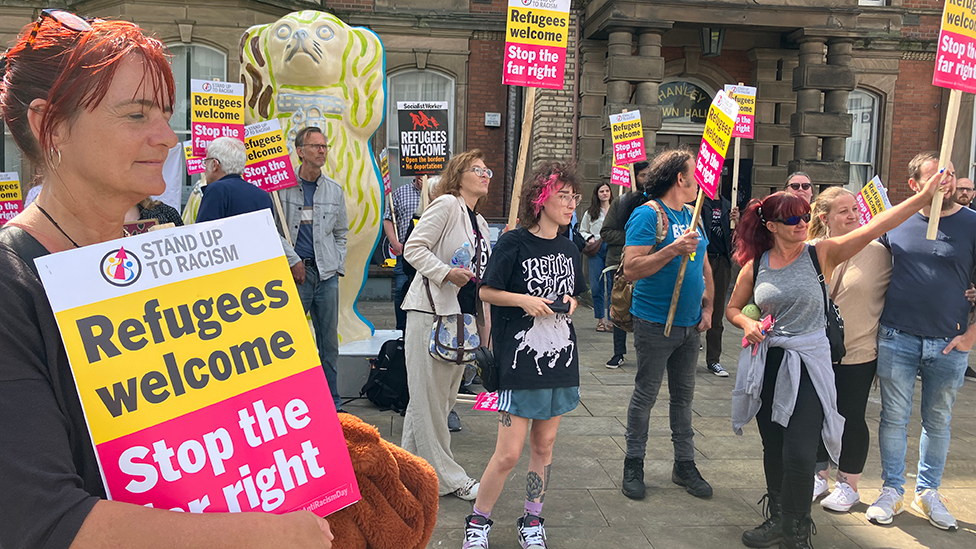 Counter protesters standing outside Hanley Town Hall, carrying placards and signs saying "Refuges welcome" and "Stop the far right"