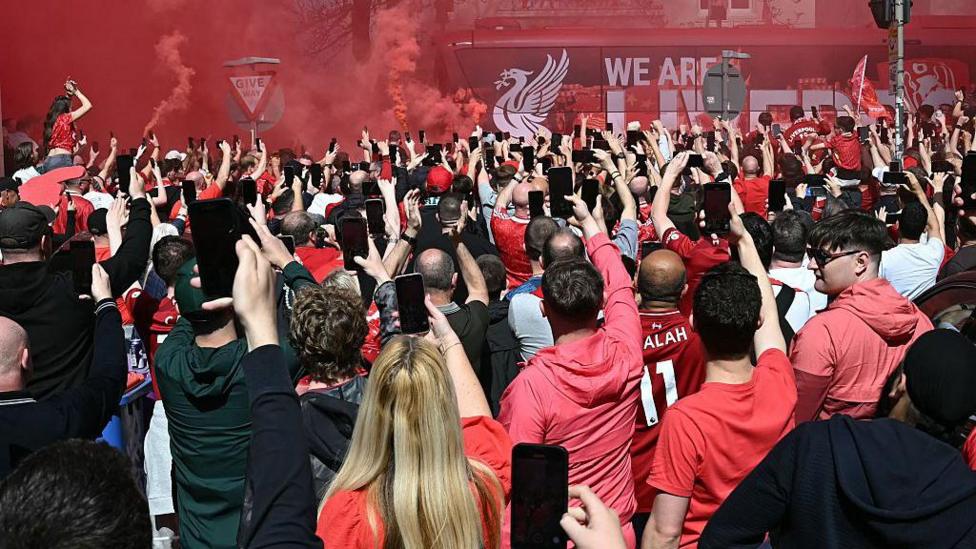 Fans welcome the Liverpool team bus as it arrives at Anfield